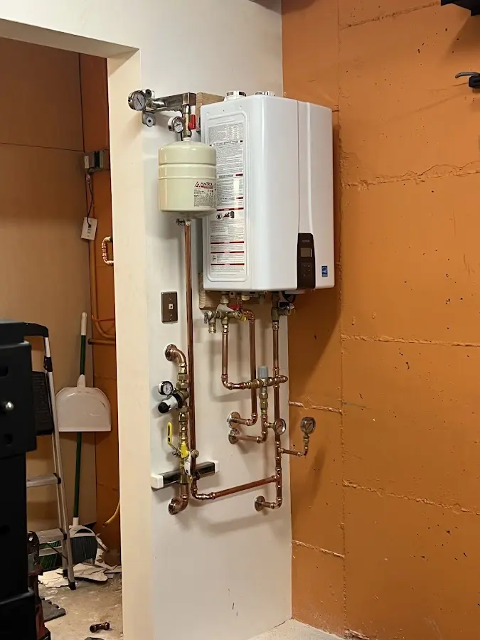 Plumbing technician inspecting water heater connections in Spring Hill